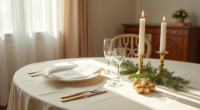 Formal place setting with brass candle holders, white plate, evergreen sprigs, and chocolates on a cream tablecloth lit by