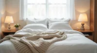 Three different blanket layers arranged on a bed showing quilted cotton, chunky knit, and linen textures from above.