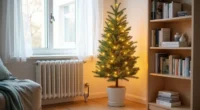 A potted evergreen tree with warm white lights stands in a studio corner between a radiator and bookshelf.