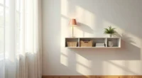 White floating shelf in office corner displaying desk lamp, woven baskets, and potted plant above bare wooden wall.