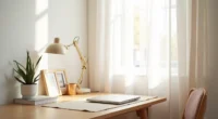 A tidy desk corner displays a succulent plant, framed photo, desk pad, and laptop on wood against white wall.