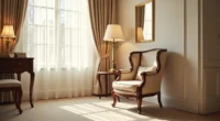 Mahogany high-back chair with scrolled armrests angled in a sunlit corner beside a side table and framed mirror.