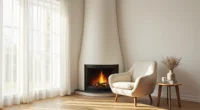 Corner fireplace with dark metal frame, cream armchair angled toward it, small side table with mug on hardwood flooring.
