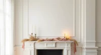 White marble mantle decorated with draped blush silk garland, dried pampas grass, and brass candleholders.