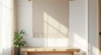 Neutral linen wall rug hanging on white shiplap above a wooden bench with afternoon light creating shadow patterns on the